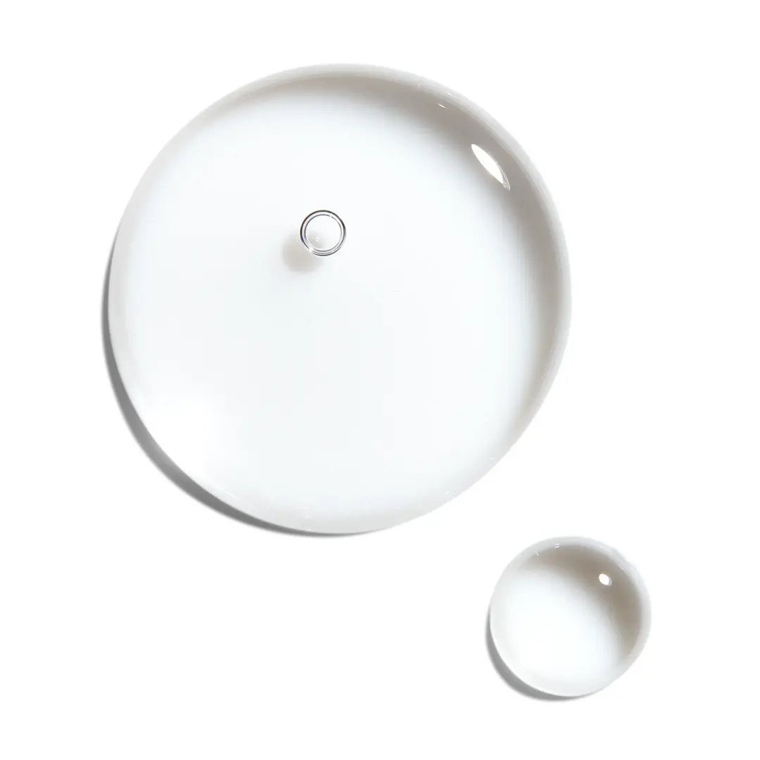 two clear droplets of the Nioxin treatment serum on white surface