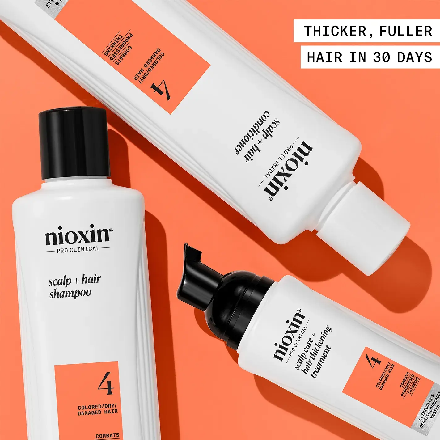 Nioxin System 4 kit products laid down against orange background