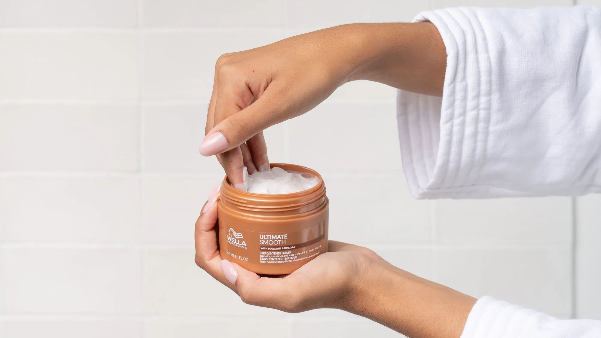 Model’s hand reaches into a jar of ULTIMATE SMOOTH Intense Mask.