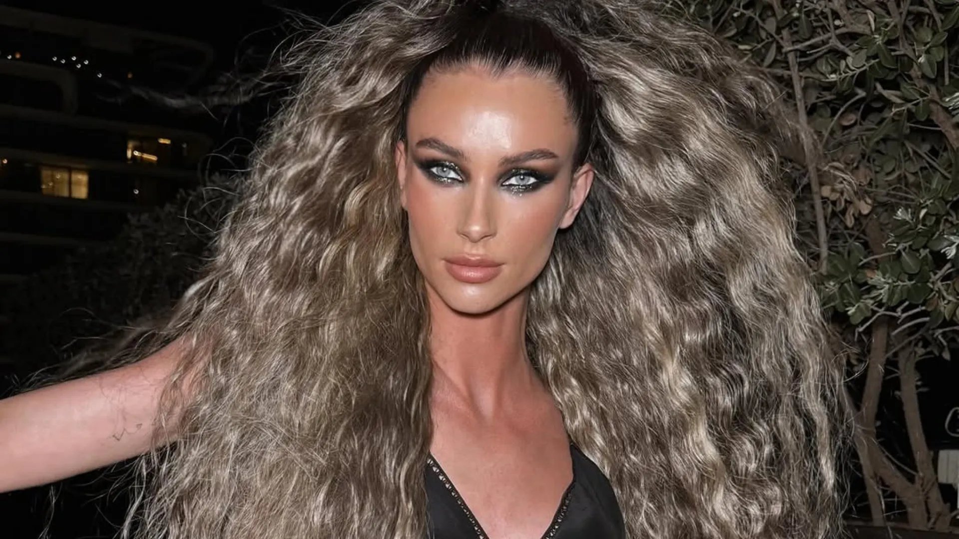 Model with ultra-long, bronde hair styled in crimped beach waves.