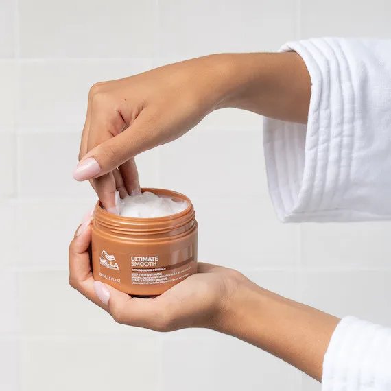 Model’s hand reaches into a jar of ULTIMATE SMOOTH Mask.