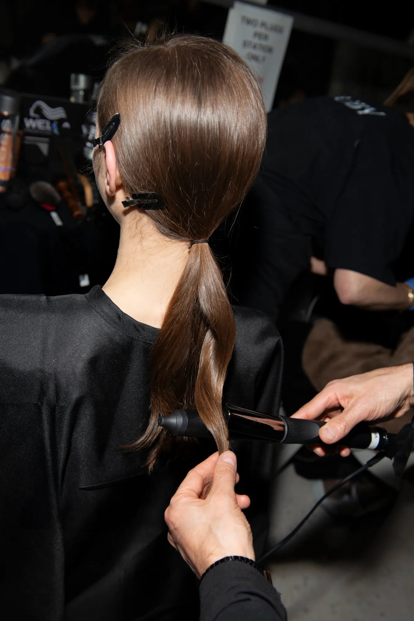 Anthony Turner sprays model’s finished sleek ponytail with hairspray. 