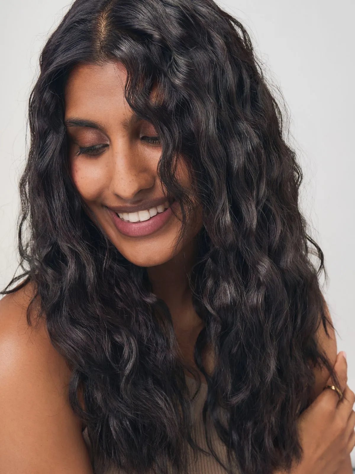 Model with long, glossy, wavy, dark brown hair.
