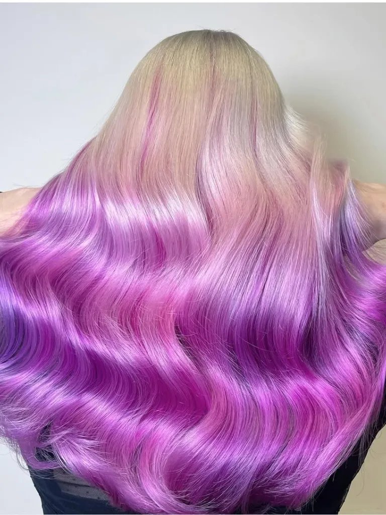 Back of model’s head with platinum blonde hair featuring vivid pink and purple colors through the lengths and ends.