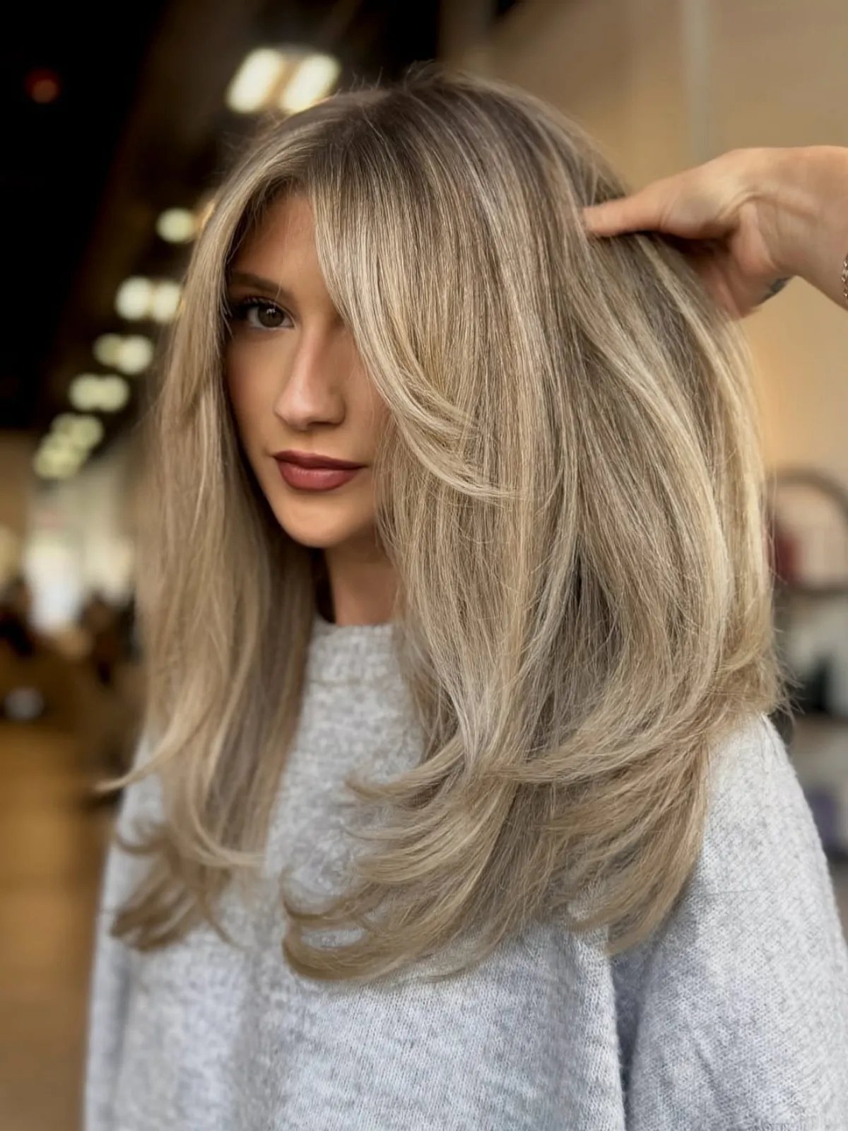 Model with long, silky, blow-dried hair featuring beige blonde highlights.