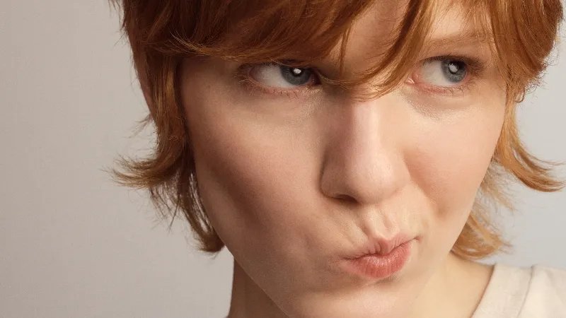 Model with short, strawberry blonde hair featuring bangs.