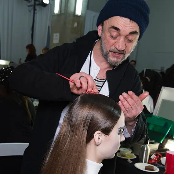 Eugene styling model's hair. 
