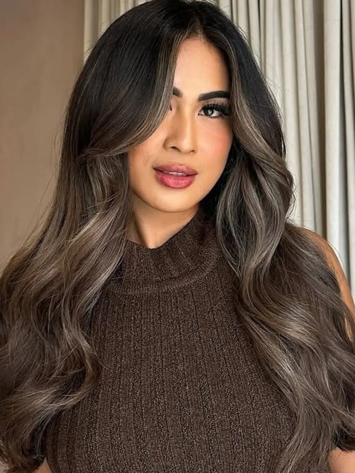 Model with long, dark brown hair featuring ash bronde face-framing highlights.