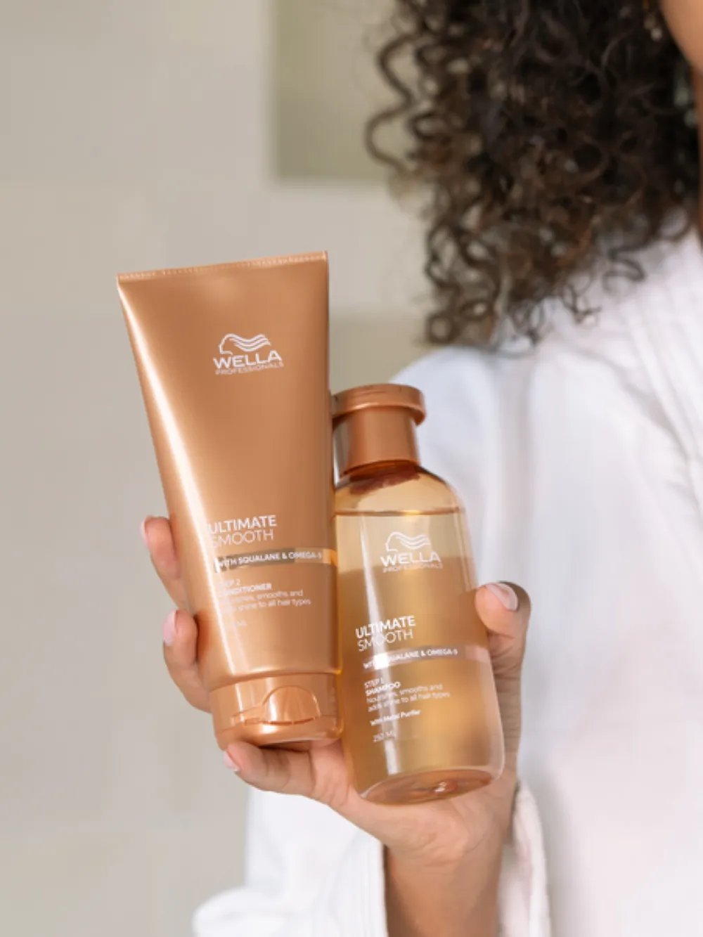 Model holding Wella Professionals hair care products in a bathroom setting
