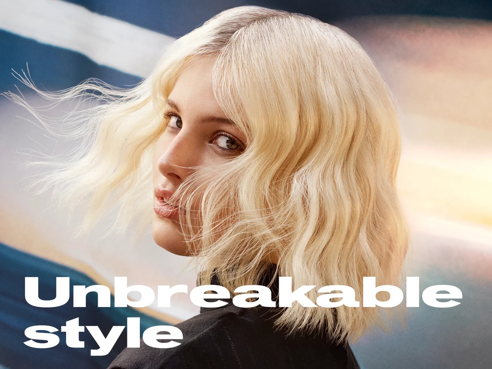 Image of model with short, blonde wavy hair looking to the side, Text overlay reads 'Unbreakable style'.
