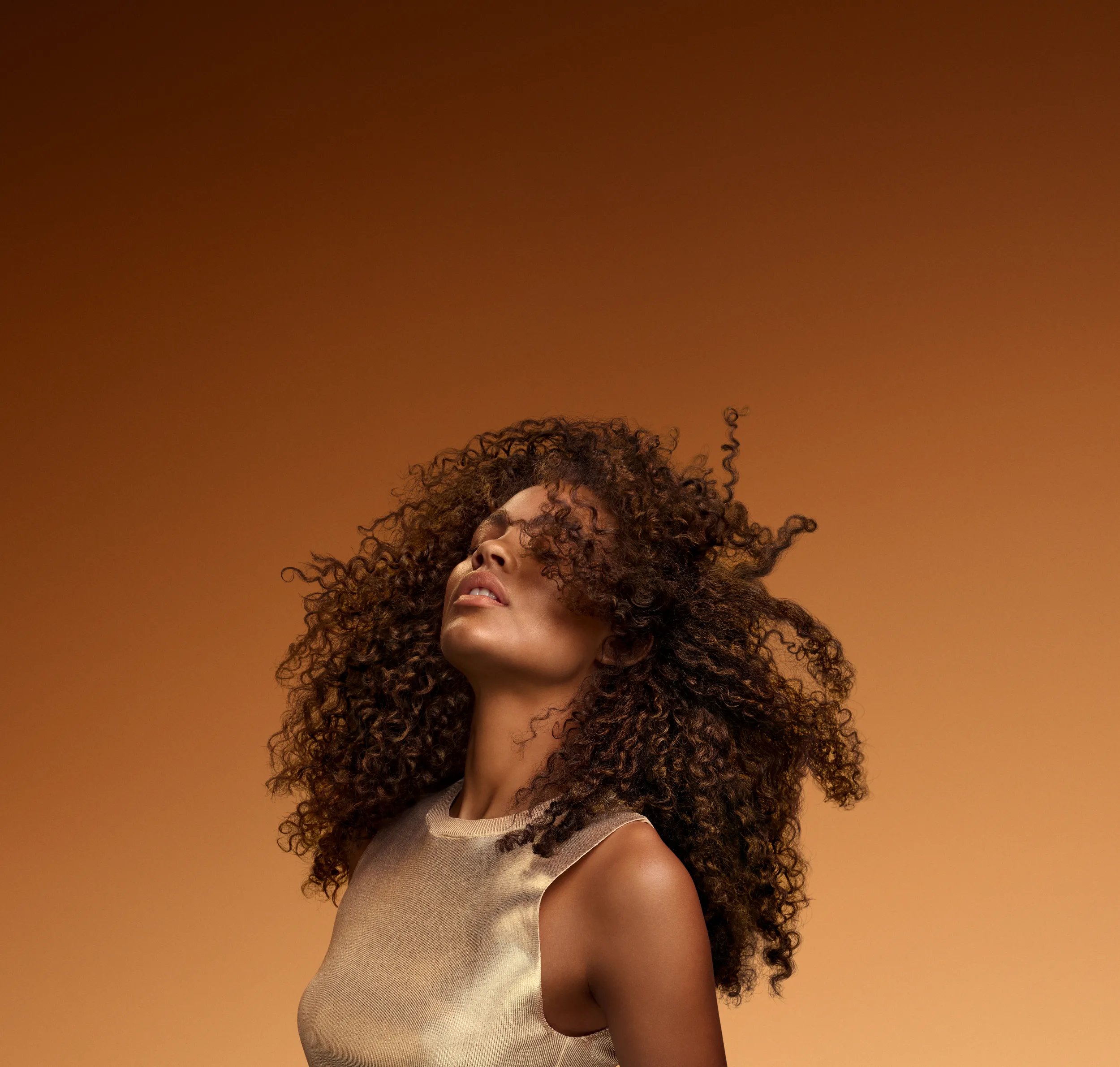 Woman with long, dark brown afro poses for the camera.