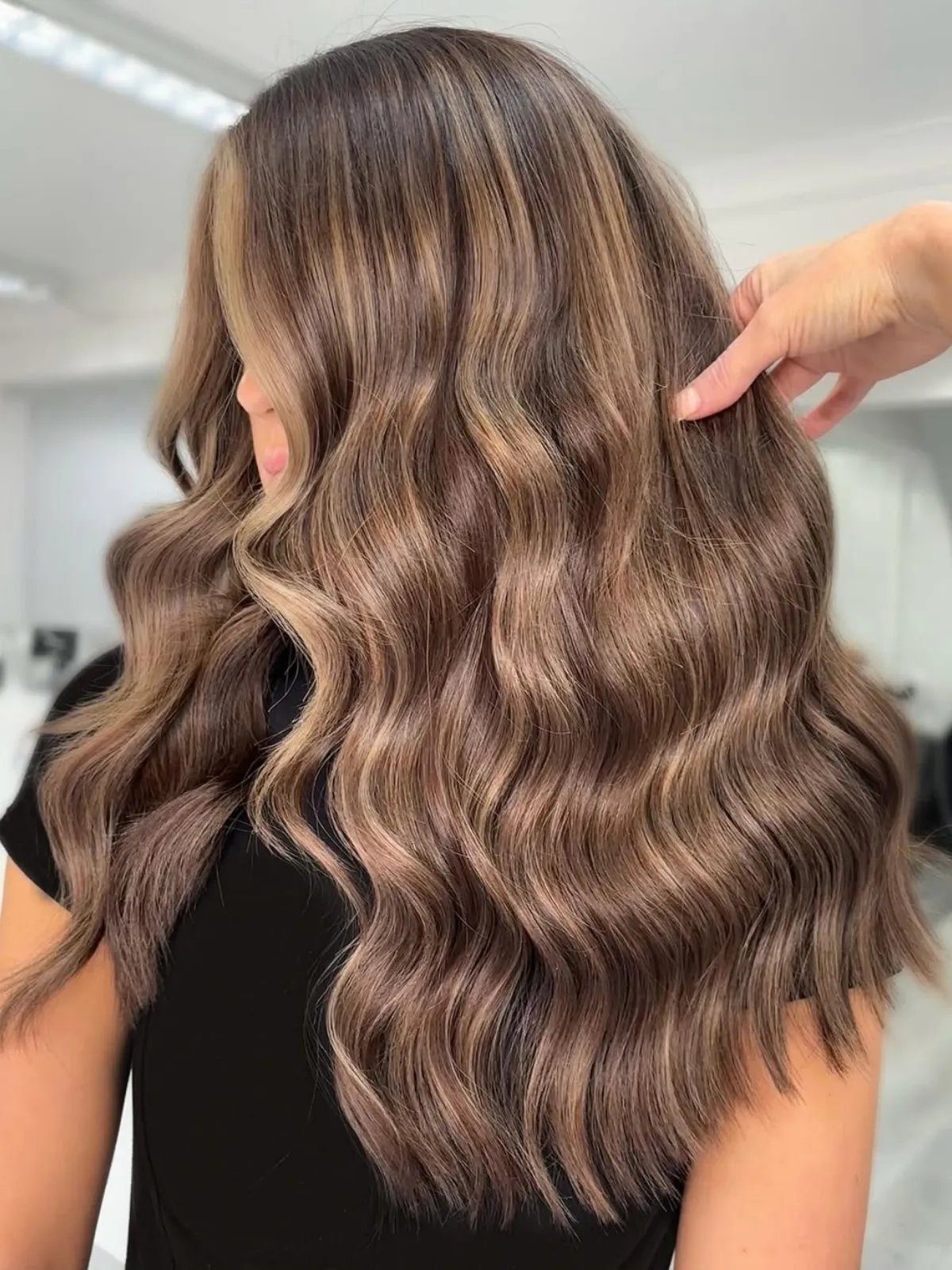 Long, medium brown hair with ash brown and blonde highlights.