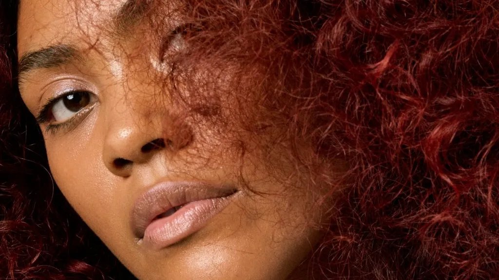 Close-up of model with frizzy, curly hair.