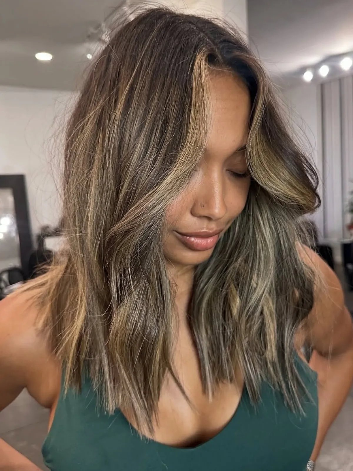 Caramel brown hair with a dark root melt and radiant bronde mid-length highlights.