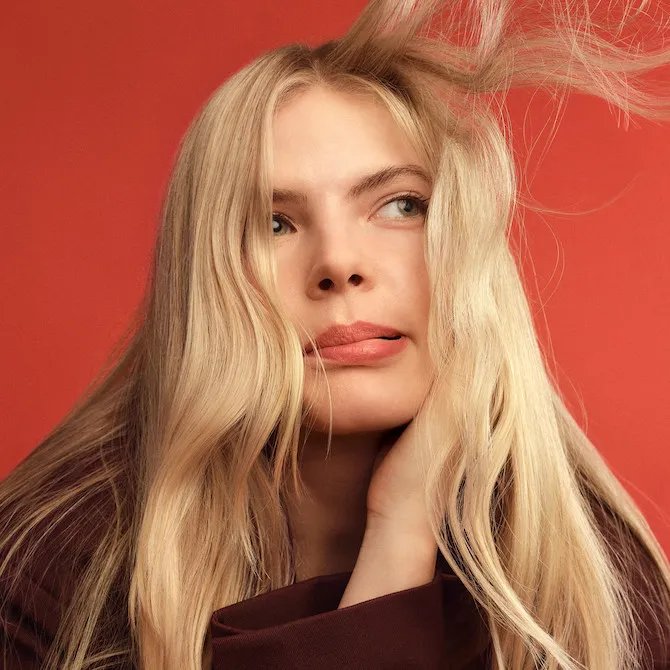 Model blowing blonde hair off their face.