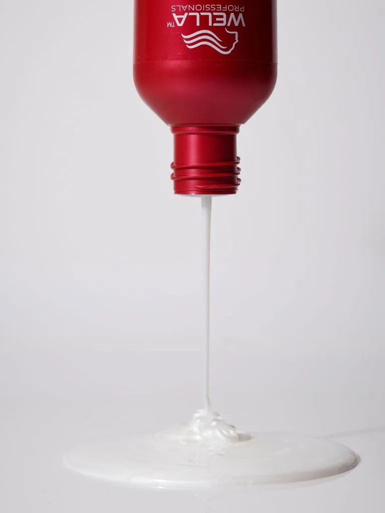 ULTIMATE REPAIR Shampoo is poured from bottle.
