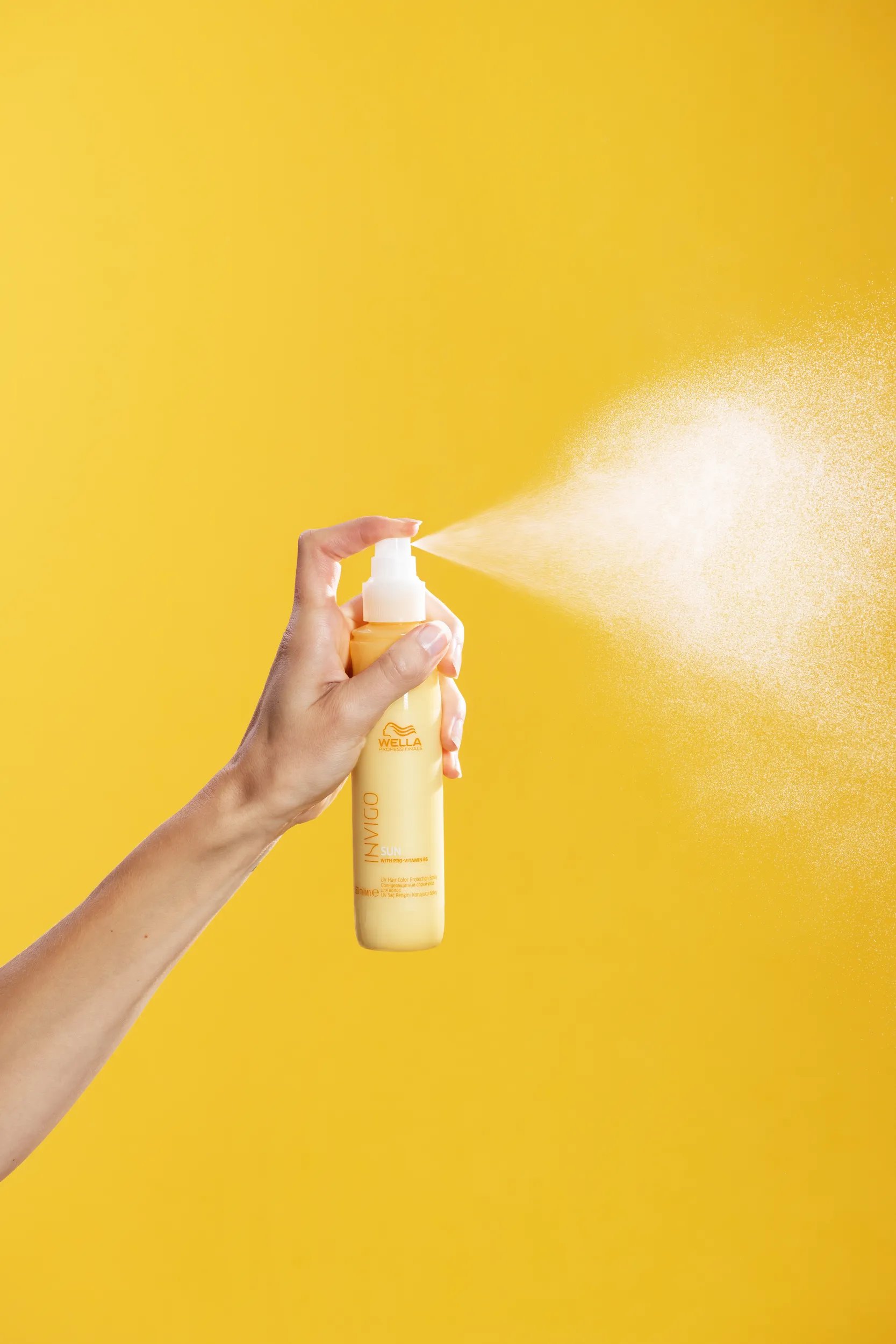 Φωτογραφία του Invigo Sun Leave-in της Wella Professionals την ώρα που γίνεται ο ψεκασμός.