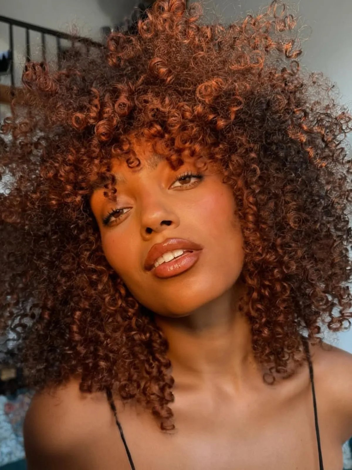Model with full, bouncy, copper bronze curls.