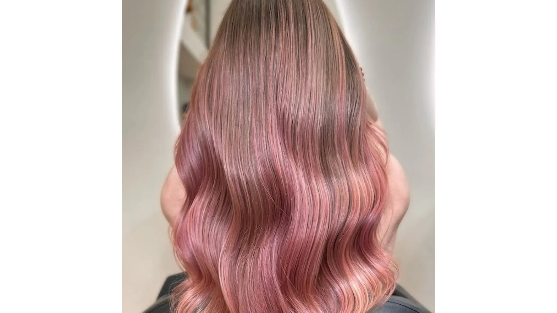 Model with dark blonde hair and a dusty pink balayage.