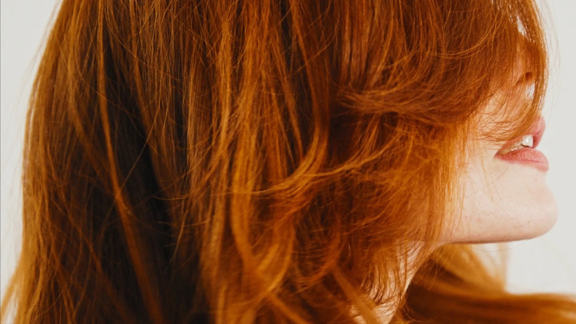 Close-up of model with bright copper red hair.