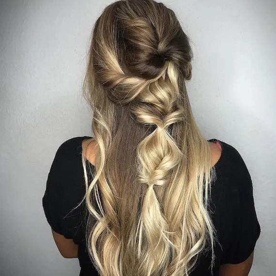 Back of woman’s head with blonde, half-up twisted braid, created using Wella Professionals.