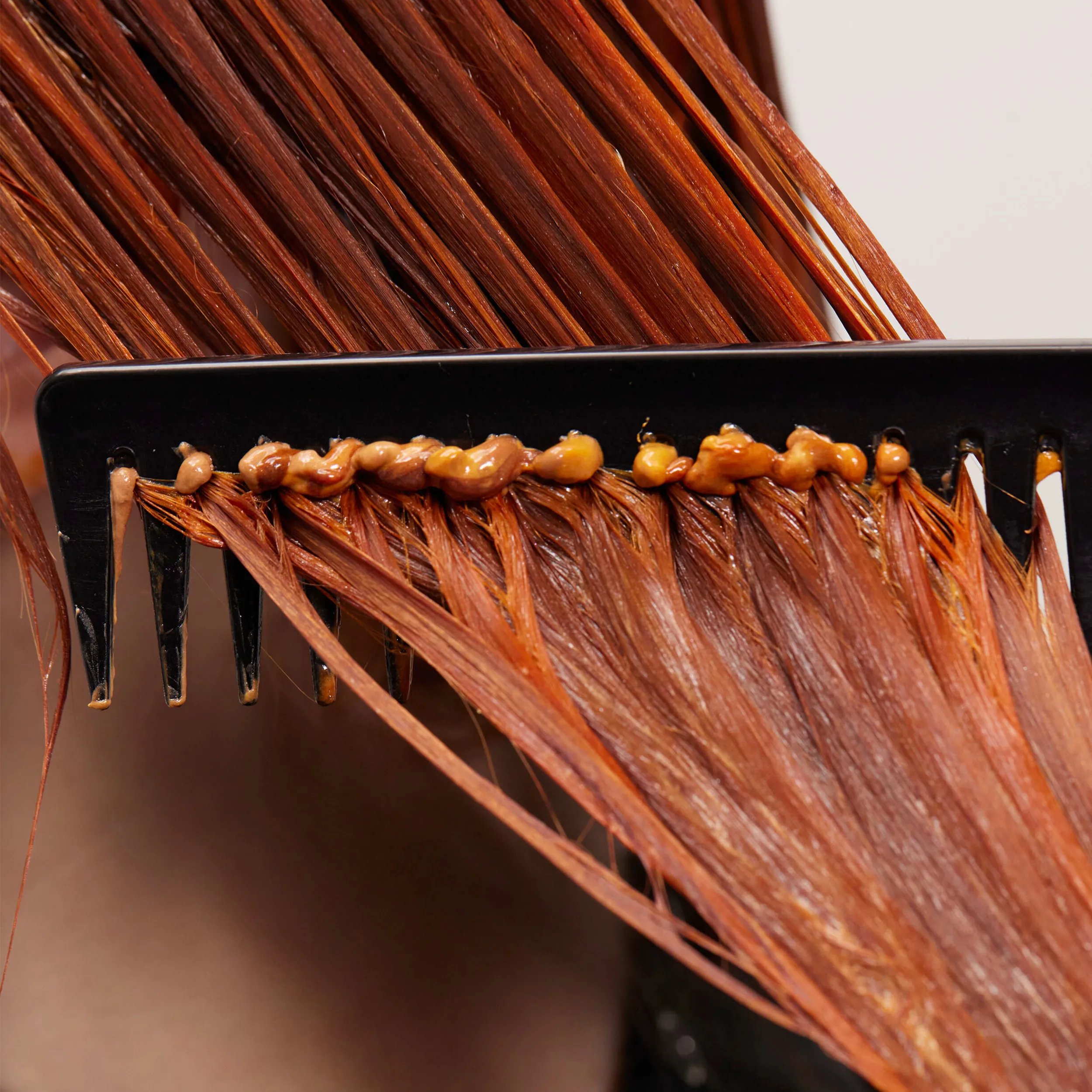 Auburn hair being combed with product buildup.