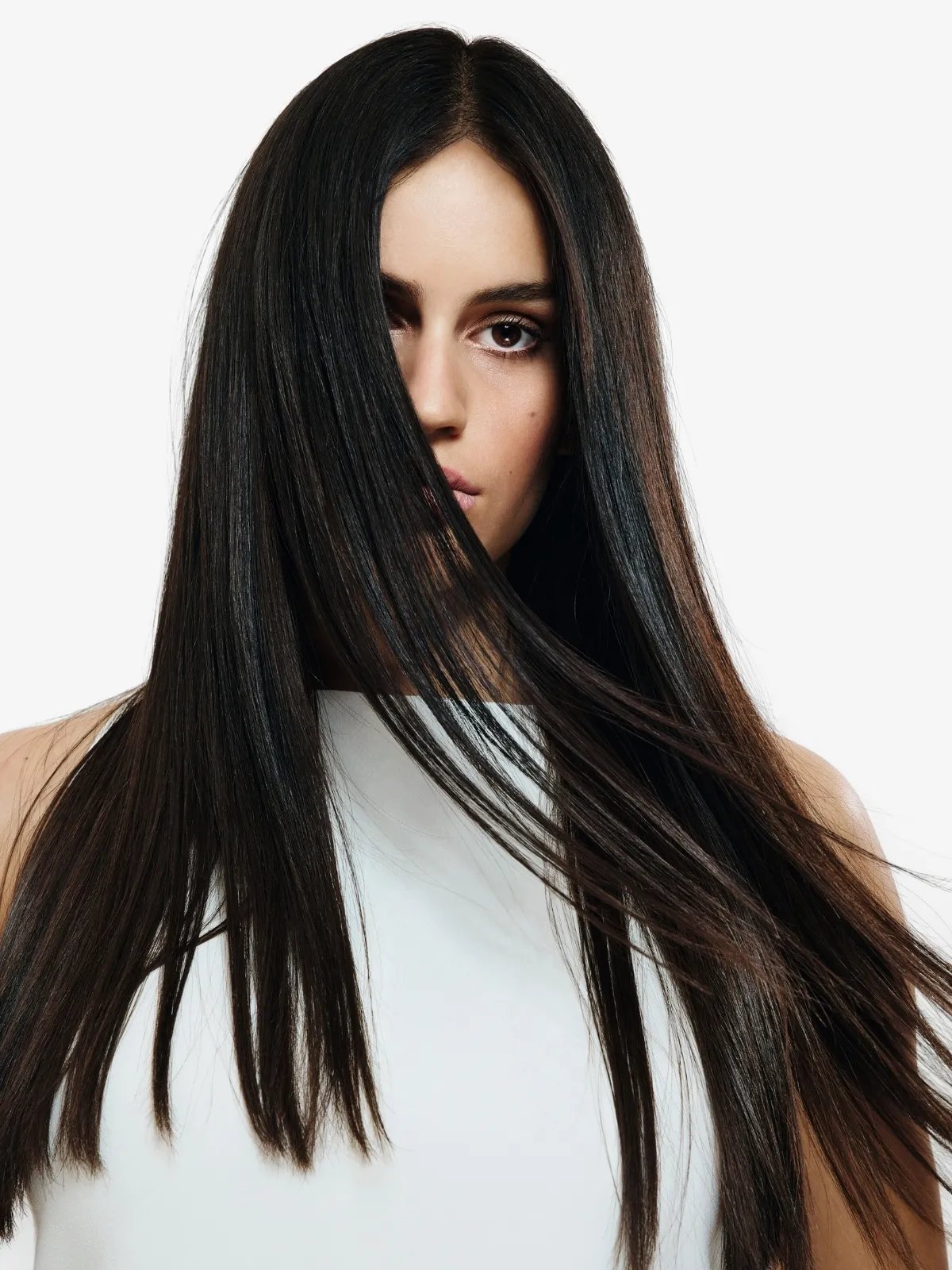 Model’s long, straight, dark brown hair partially covers their face.