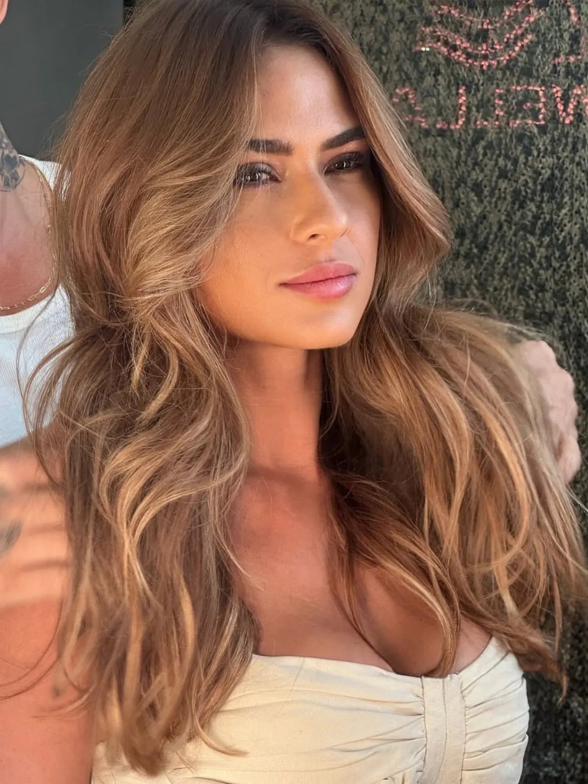 Model with bronzy tones through a dark blonde and brown balayage.