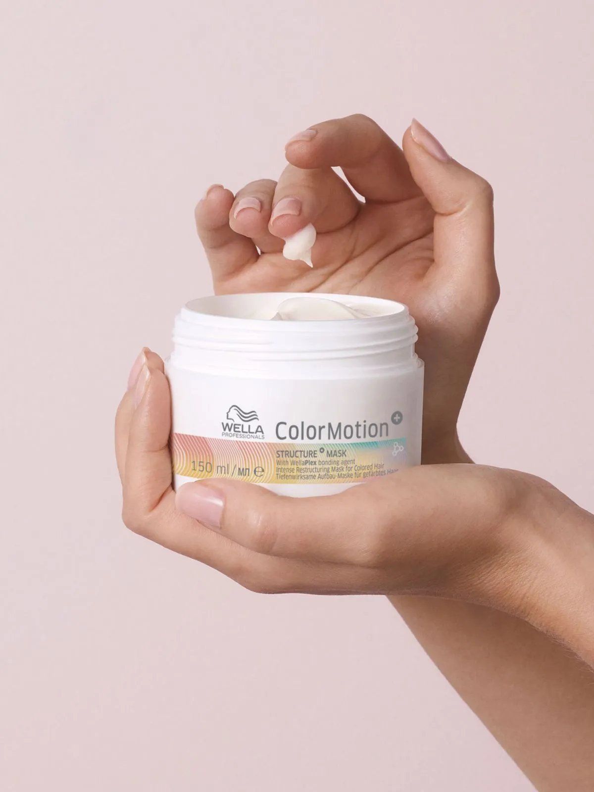 Model’s hand reaches into jar of ColorMotion+ Structure+ Mask.