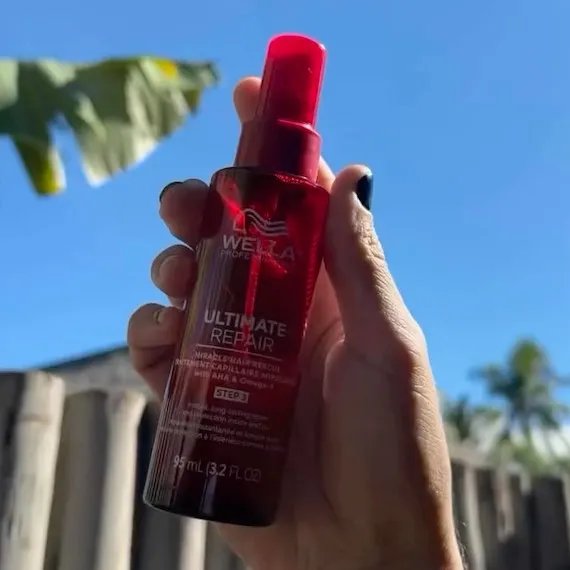 ULTIMATE REPAIR Miracle Hair Rescue held up in front of a blue sky background.