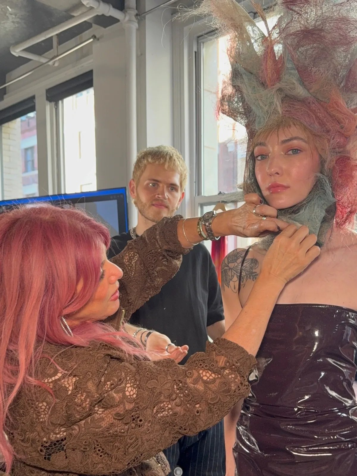 Renya Xydis fixes hair fabric to a model’s hair during a styling demonstration.