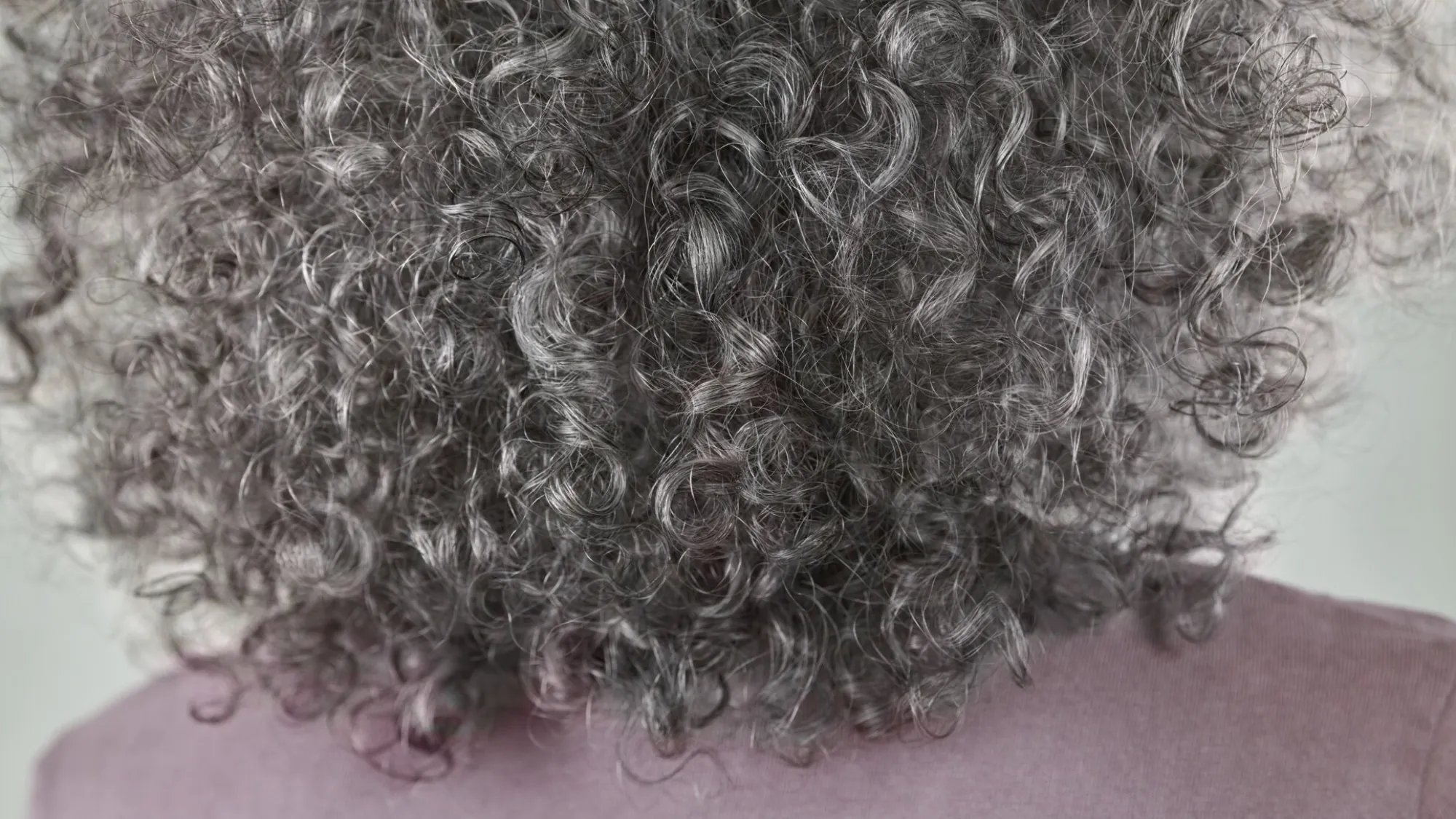 Close-up of grey hair featuring long, straight strands of hair, showcasing its texture and colour.