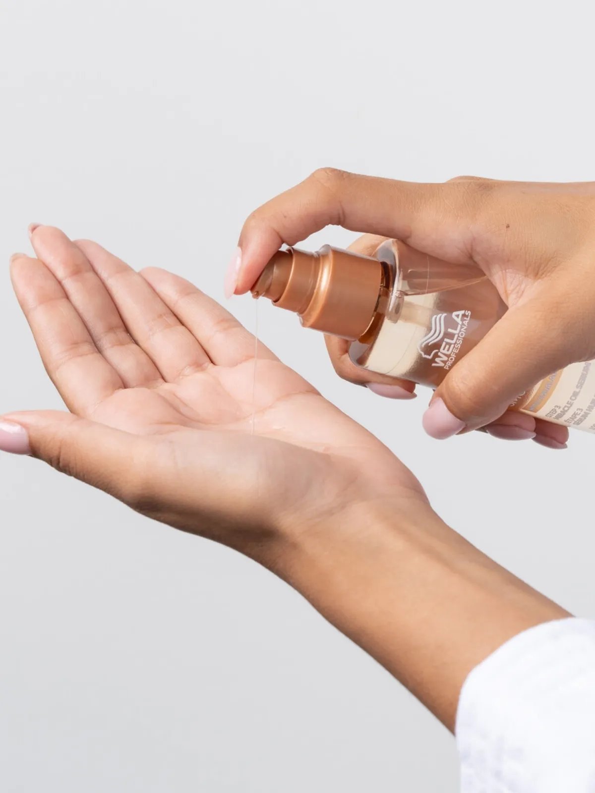 Model pumps ULTIMATE SMOOTH Miracle Oil Serum into palm of hand.