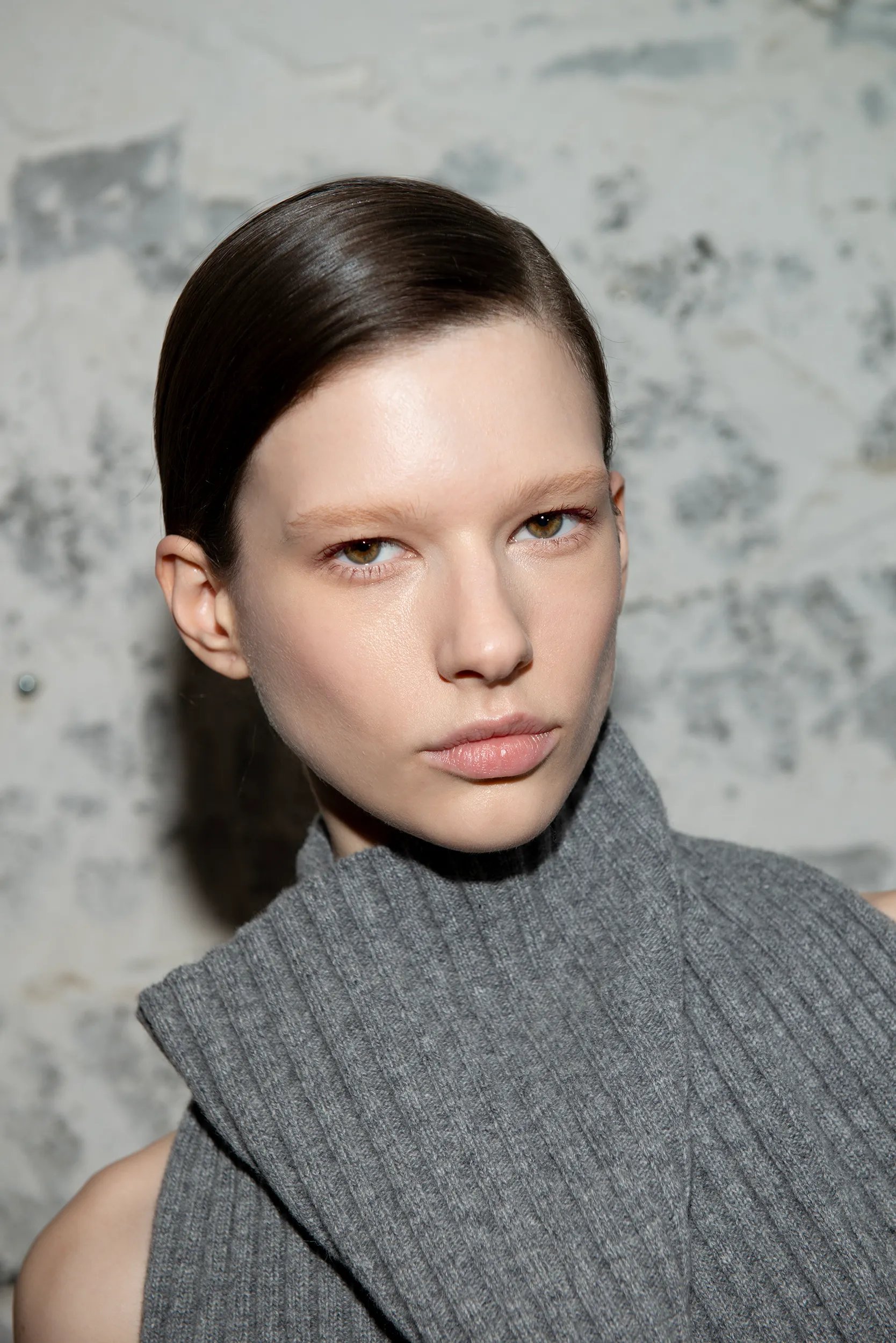 A model with a sleek side ponytail looking at the camera