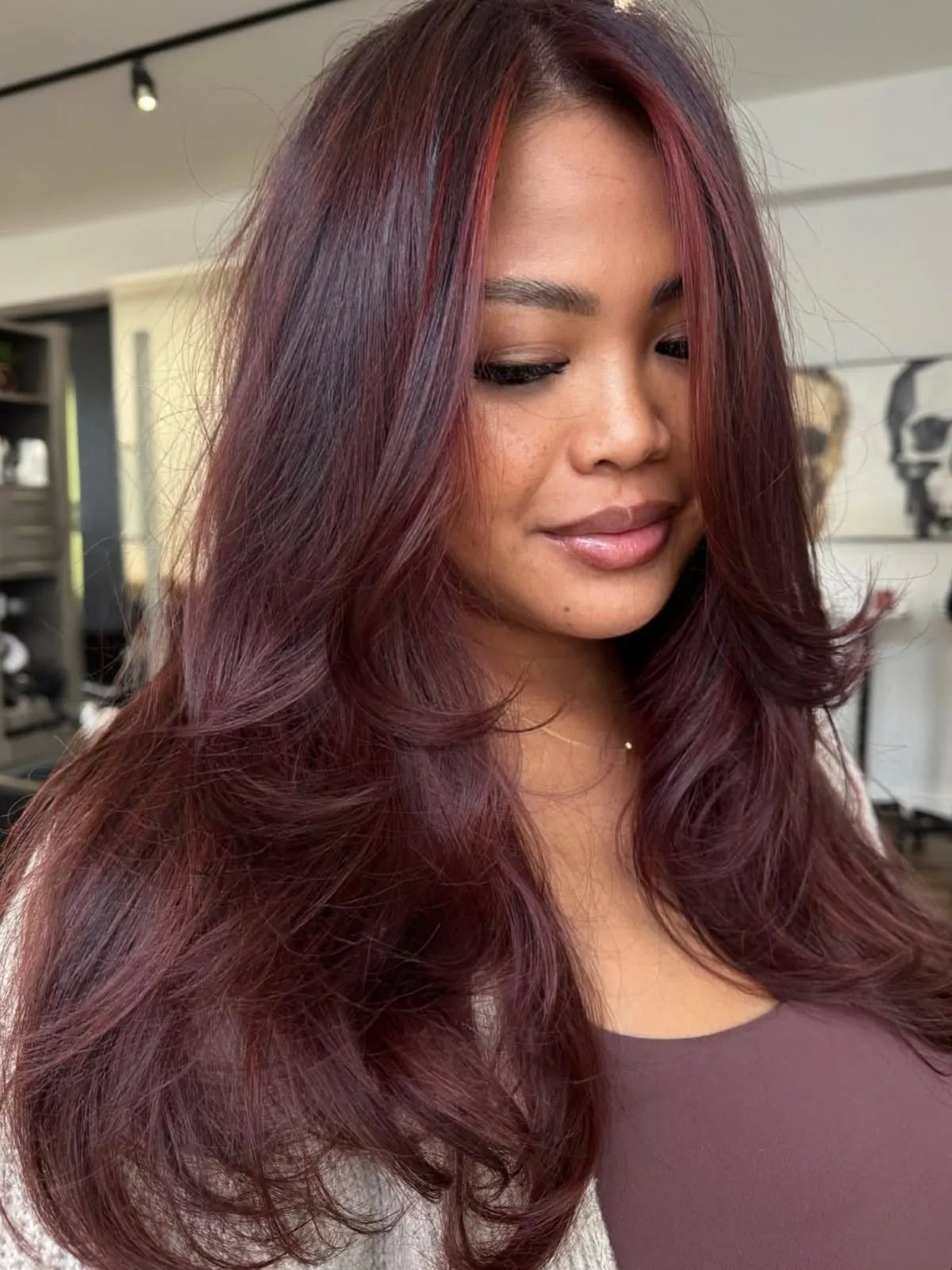 Model with dark merlot red hair featuring brighter cherry tones through the front. 